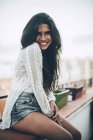 Ritratto di giovane donna sorridente seduta al balcone — Foto stock