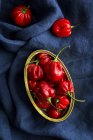 Scatola di latta piena di peperoni rossi su panno blu scuro — Foto stock