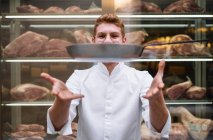 Шеф-повар в очках и белом халате рвет сковородку, работающую в ресторане. — стоковое фото