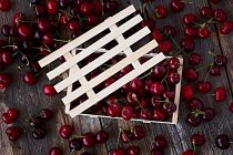 Caixa de madeira de deliciosas cerejas maduras em madeira marrom — Fotografia de Stock
