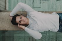 Young handsome man lying on concrete wall — Stock Photo