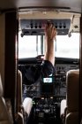 Hombre irreconocible en el avión piloto de auriculares? solo mientras está sentado en la cabina de los aviones modernos - foto de stock