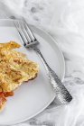 Macarrones con queso y chorizo en plato blanco con tenedor - foto de stock