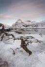 Strato di ghiaccio incrinato sull'acqua con montagne in inverno — Foto stock