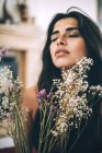 Молода чуттєва жінка з закритими очима позує з квітами — стокове фото