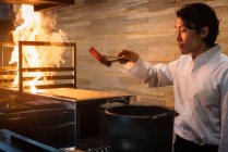 Cocinero cocinando en restaurante preparando carbón - foto de stock
