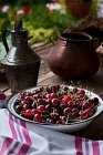 Cerejas frescas em tigela de metal na mesa de madeira marrom — Fotografia de Stock