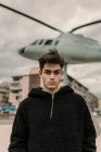 Schöner junger Mann steht am Hubschrauberdenkmal an der Stadtstraße — Stockfoto