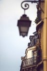 Крупный план фасада здания с размытым фонарем на стене, Париж, Франция — стоковое фото