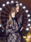Sensual brunette wearing lace black dress on nude body covering eyes in flash light — Stock Photo