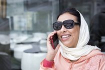 Primer plano de la mujer marroquí con hijab hablando por teléfono - foto de stock