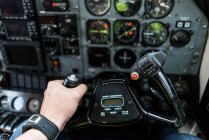 Рука неузнаваемого пилота, управляющая современными самолетами с помощью колеса управления — стоковое фото