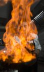 Взволнованный повар готовит фламбе на кухне ресторана — стоковое фото