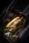 Pollo entero crudo listo para asar en una bandeja para hornear con ingredientes - foto de stock