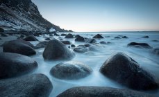 Rocce lisce nel flusso dell'acqua sotto il cielo blu — Foto stock