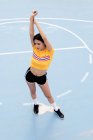 Schlanke junge Frau in Sportkleidung steht auf blauem Sportplatz — Stockfoto