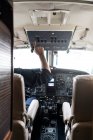 Hombre irreconocible en el avión piloto de auriculares? solo mientras está sentado en la cabina de los aviones modernos - foto de stock