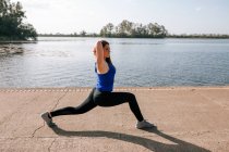 Giovane donna che fa sport vicino al lago — Foto stock