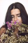 Blooming flowers and sensual young woman on background — Stock Photo