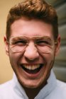 Close-up of cheerful bright redhead man in stylish glasses looking at the camera crazily with excitement. — Stock Photo