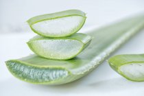 Trozos de Aloe Vera verde fresco con pulpa blanca sobre fondo claro. - foto de stock