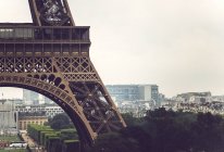 Part of Eiffel Tower on background of cityscape of Paris, France — Stock Photo
