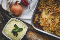 Запечені макарони з сиром і хорізо в сковороді на сільському столі з інгредієнтами — стокове фото