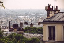 Vue sur les arbres et les toits des maisons couverts de brouillard à Paris, France — Photo de stock