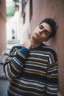 Young pensive teenager in sweater standing on city street — Stock Photo