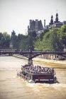 Lancha a motor sobre el río Sena sobre el fondo de árboles verdes y el Louvre, París, Francia - foto de stock