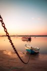 Liegeplatz Boot auf Kette im flachen Wasser des ruhigen Hafens im Sonnenuntergang Licht, Spanien — Stockfoto
