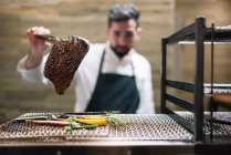 Chef cooking in restaurant preparing beef roast — Stock Photo