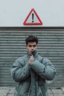 Портрет підлітком у теплих сірий жакет стоячи під знаком на вулиці — стокове фото