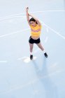 Magro jovem mulher em sportswear pé no chão de esportes azuis — Fotografia de Stock