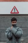 Ritratto di adolescente in giacca grigia caldo in piedi sotto segno sulla strada — Foto stock
