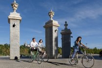 Весёлые азиаты катаются на велосипедах в парке — стоковое фото