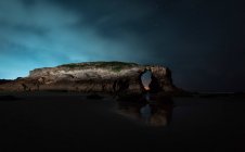 Falaise voûtée située près de la mer calme la nuit dans la nature, Asturies, Espagne — Photo de stock