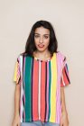 Portrait de jeune femme confiante en chemise rayée colorée — Photo de stock