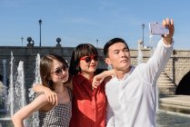 Asian tourists taking selfie near fountain — Stock Photo