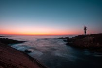View of beacon on coast near sea during majestic sunset in cloudless evening, Asturias, Spain — Stock Photo
