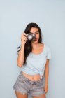 Jovem mulher em t-shirt e calções jeans atirando na câmera — Fotografia de Stock