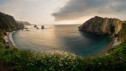 Magnificent round sea bay at sunset in cloudy evening, Asturias, Spain — Stock Photo