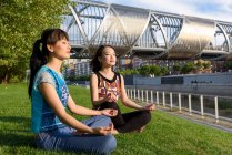 Mujeres asiáticas meditando en el parque - foto de stock