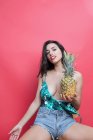 Jovem mulher sedutora posando com abacaxi no fundo rosa — Fotografia de Stock