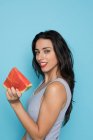 Portrait of young woman holding piece of watermelon on blue background — Stock Photo