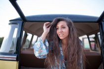 Красива і молода жінка насолоджується поїздкою у старовинному фургоні з деякими друзями — стокове фото