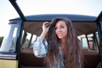 Beautiful and young woman enjoys the trip in her vintage van with some friends — Stock Photo