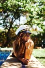 Mulher de chapéu capitão deitado perto da piscina — Fotografia de Stock