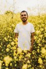 Чоловік стоїть серед жовтих квітів — стокове фото