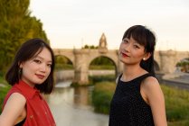 Young Asian women near fence in park — Stock Photo